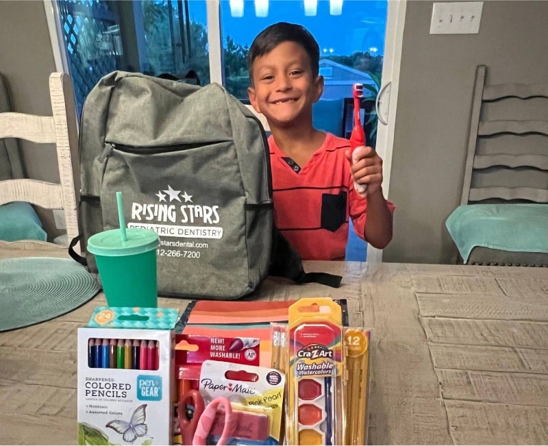 smiling kid with school supplies