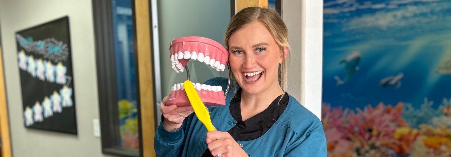 smiling staff member with teeth prop